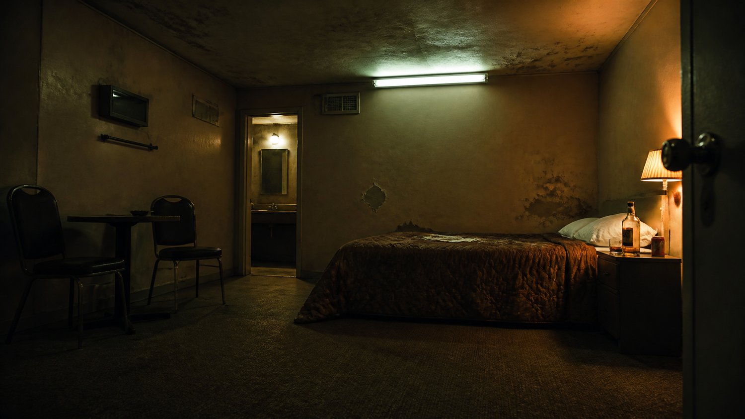 Adventure Motel — A cheap hourly motel: peeling paint, a buzzing tube-light, a sagging bed, a whisky bottle, no CCTV — chosen for exactly that. Where the ritual unfolds.