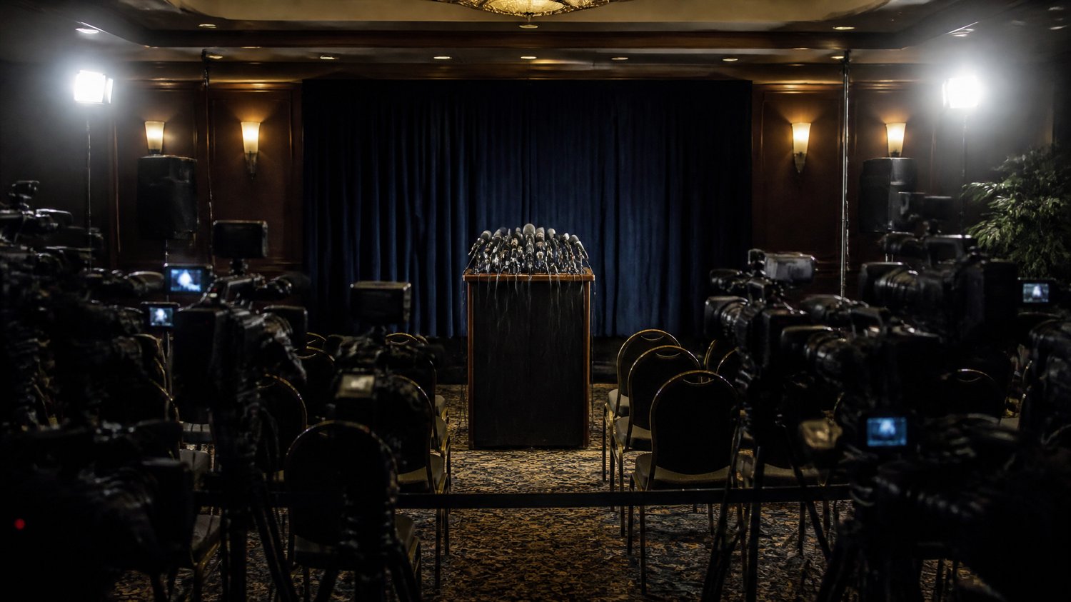 The Press Conference — The media glare that haunts every move — the case lived out in public, under flashbulbs.